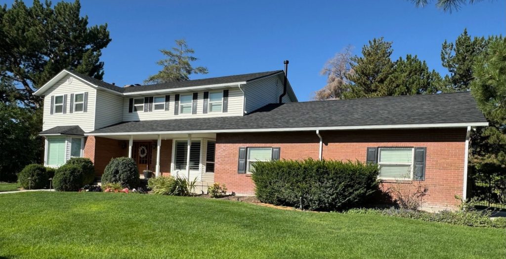 New black roof shingles against white siding and brick in SLC